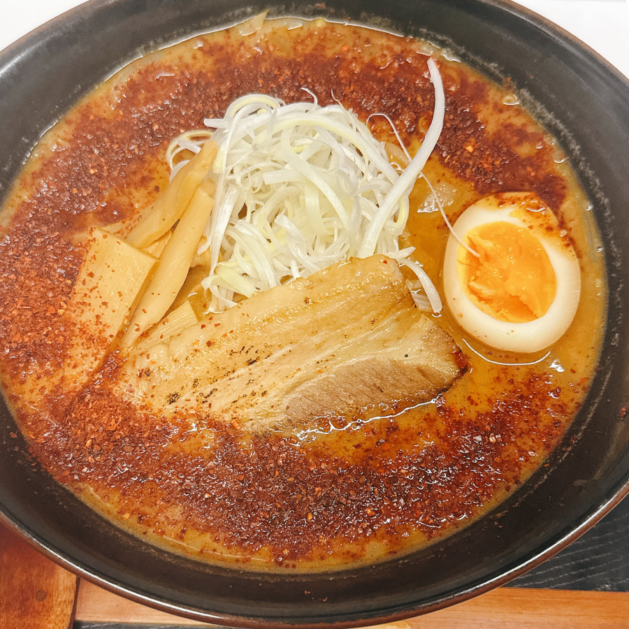 熱々の辛味噌ラーメン、赤いスープとトッピングが映える写真
